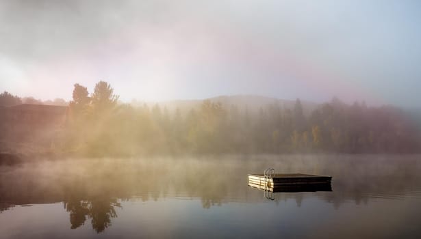 view of a boat dock the Lac-Superieur, misty morning with fog, in Laurentides, Mont-tremblant, Quebec, Canada