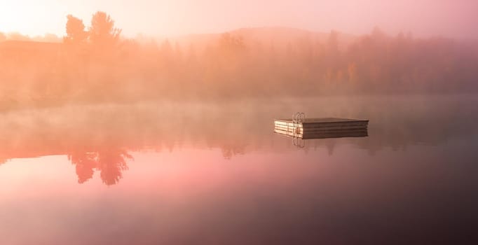 view of a boat dock the Lac-Superieur, misty morning with fog, in Laurentides, Mont-tremblant, Quebec, Canada