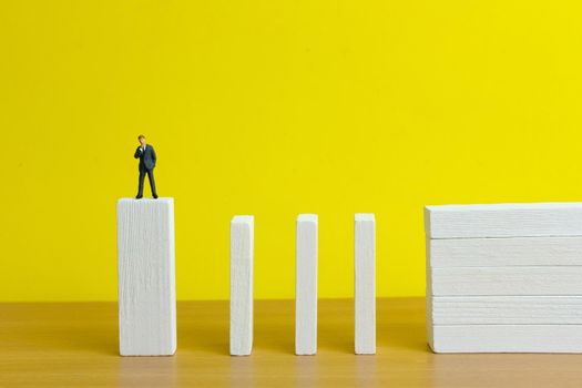 Business strategy conceptual photo - Miniature of businessman stands at the edge of wooden bridge staircase. Image photo