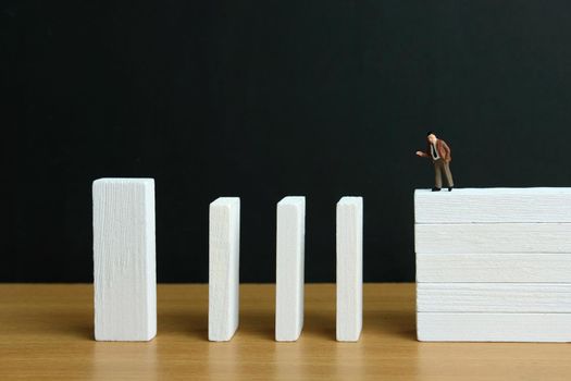 Business strategy conceptual photo - Miniature of businessman stands at the edge of wooden bridge staircase. Image photo