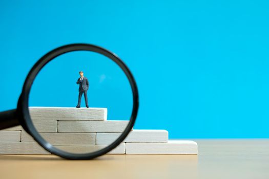 Business strategy conceptual photo - Miniature of businessman stands on a podium. Image photo