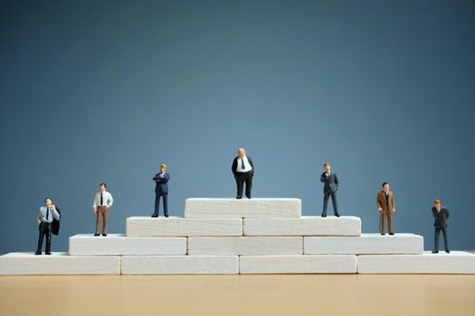 Business strategy conceptual photo - Miniature of businessman stands on a podium. Image photo