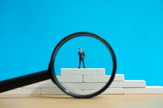 Business strategy conceptual photo - Miniature of businessman stands on a podium. Image photo