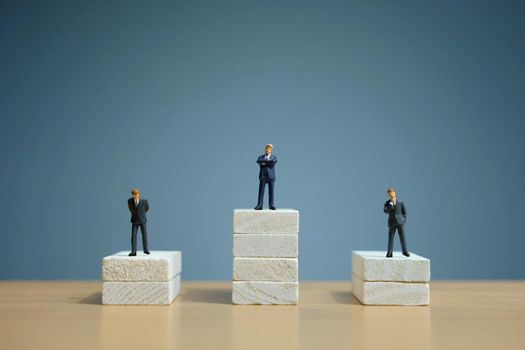 Business strategy conceptual photo - Miniature of businessman stands on a podium. Image photo