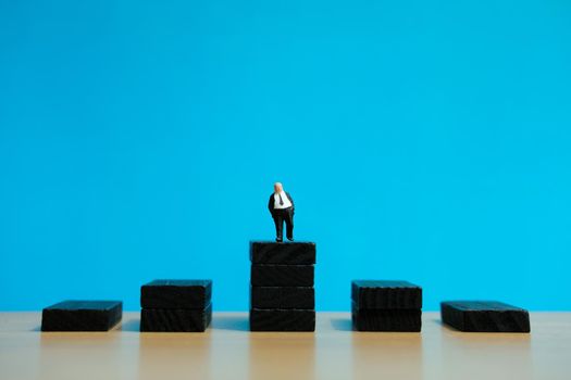 Business strategy conceptual photo - Miniature of businessman stands on a podium. Image photo