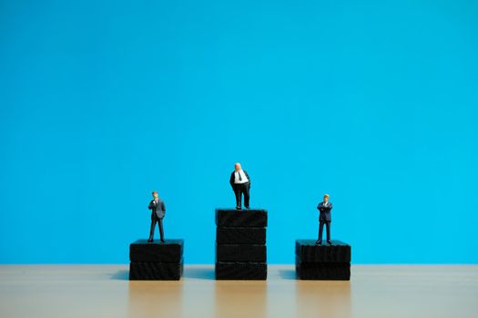 Business strategy conceptual photo - Miniature of businessman stands on a podium. Image photo