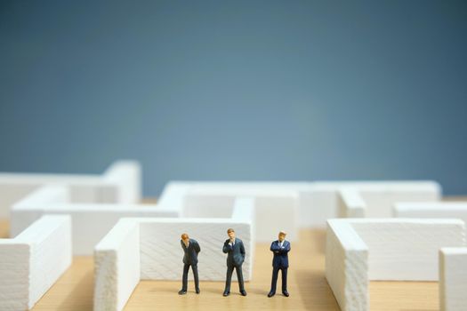 Business strategy conceptual photo - Miniature of businessman looking for solution on a labyrinth maze. Image photo