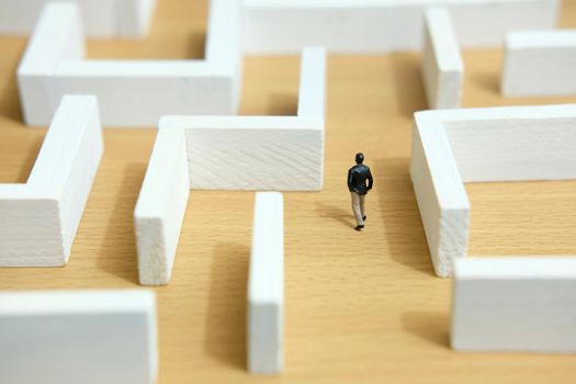 Business strategy conceptual photo - Miniature of businessman looking for solution on a labyrinth maze. Image photo