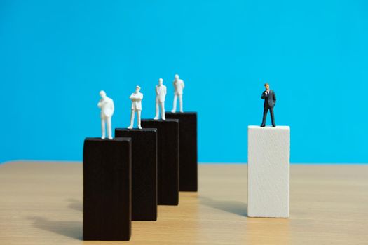 Business strategy conceptual photo – miniature of businessman stands on wooden wall. Image photo