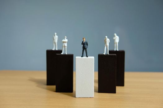 Business strategy conceptual photo – miniature of businessman stands on wooden wall. Image photo