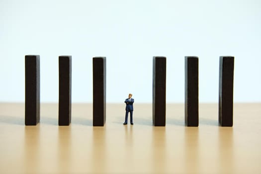 Business strategy conceptual photo - Miniature of businessman walking in the middle of barrier wall. Image photo