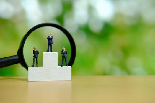 Business conceptual photo – miniature of businessman stands on wooden podium. Image photo