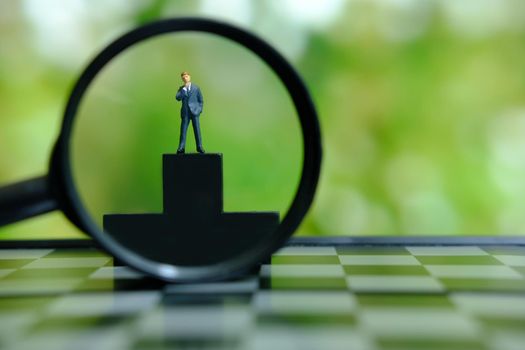 Business conceptual photo – miniature of businessman stands on wooden podium. Image photo