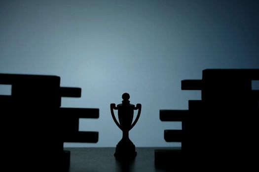 Business strategy conceptual photo – Silhouette of trophy stand in the middle of jigsaw puzzle. Image photo