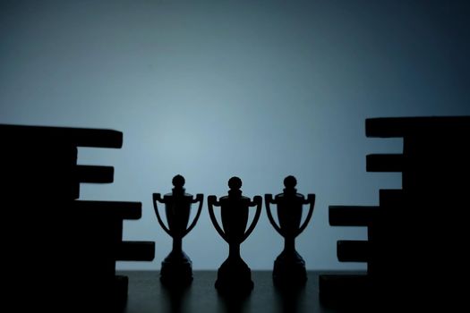 Business strategy conceptual photo – Silhouette of trophy stand in the middle of jigsaw puzzle. Image photo