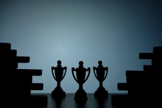 Business strategy conceptual photo – Silhouette of trophy stand in the middle of jigsaw puzzle. Image photo