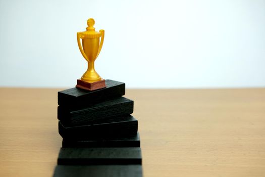 Golden trophy standing on white podium. Image photo
