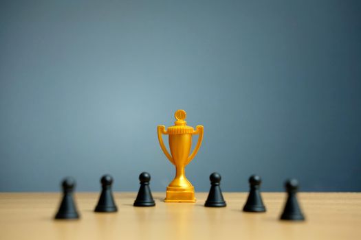 Golden trophy in the middle of chess pawn. Image photo