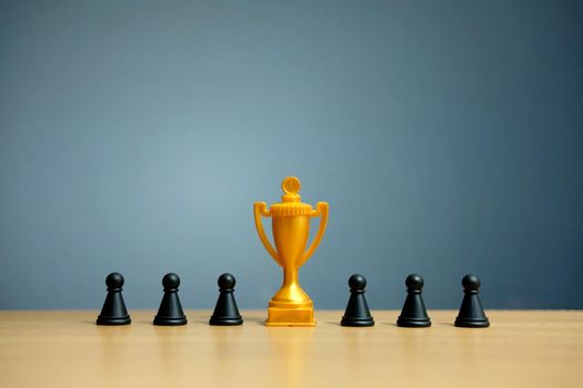 Golden trophy in the middle of chess pawn. Image photo