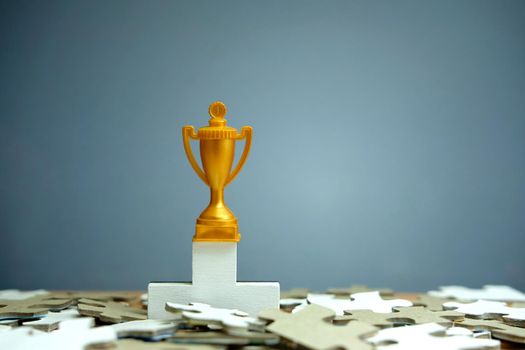 Golden trophy standing on white podium. Image photo