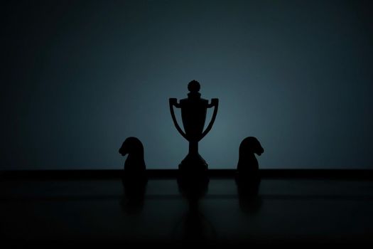 Business strategy conceptual photo – Silhouette of trophy stand in office table with chess pawn. Image photo