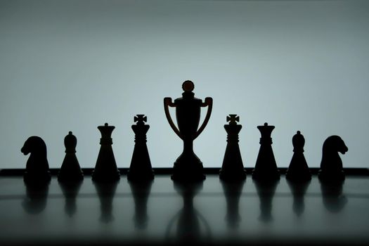 Business strategy conceptual photo – Silhouette of trophy stand in office table with chess pawn. Image photo