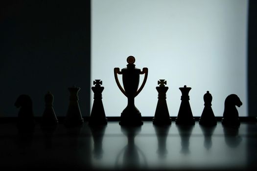 Business strategy conceptual photo – Silhouette of trophy stand in office table with chess pawn. Image photo