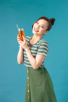 Pretty young woman holding glass of soft drink in hands