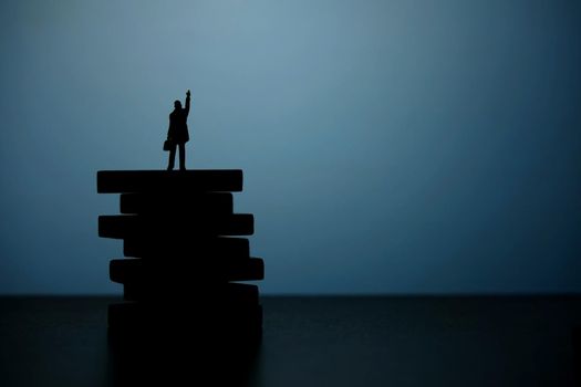 Business strategy conceptual photo - Silhouette of miniature businessman pointing upside above wooden staircase. Image photo