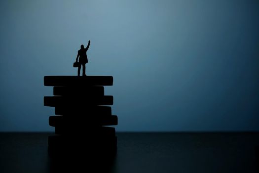 Business strategy conceptual photo - Silhouette of miniature businessman pointing upside above wooden staircase. Image photo