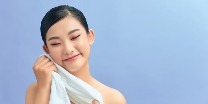 attractive asian woman using towel over light blue