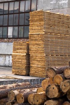 Storage of piles of wooden boards on the sawmill. Boards are stacked in a carpentry shop. Sawing drying and marketing of wood. Pine lumber for furniture production, construction. Lumber Industry