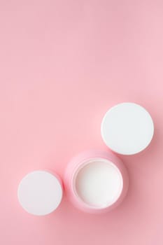 Layout on a pink cream background . Cosmetology. Care cosmetics. Skin care. Jars of cream. Pink background. Copy space. Article about the choice of cream. Spa. Spa treatments .