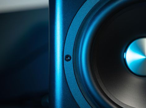 Front close up view of modern sub-woofer with blue highlights. Close-up of bass speaker. Music, sound concept.