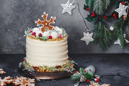 Christmas Cranberry Layer Cake. Delicious Christmas cranberry layer cake with sugared rosemary sprigs, cranberries, coconut balls and gingerbread cookie on top. Selective focus, copy space