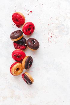 Valentine's Day Donuts. Colorful mini  donuts with chocolate, icing and sugar sprinkles on rustic wooden background