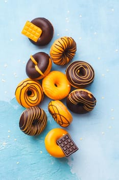 Tasty Glazed Donuts.  Mini  donuts with chocolate on rustic blue background. Top view, blank space