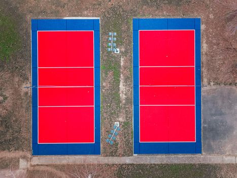 Aerial view of a red and blue  outdoor volleyball fields. Outdoor sport grounds with red and blue plastic surface for playing volleyball, winter shot