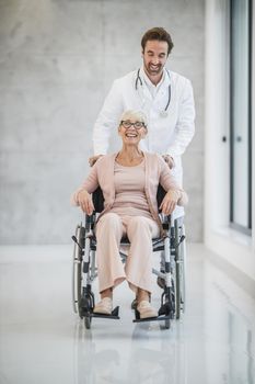 Shot of a young doctor caring a senior female patient in a wheelchair.