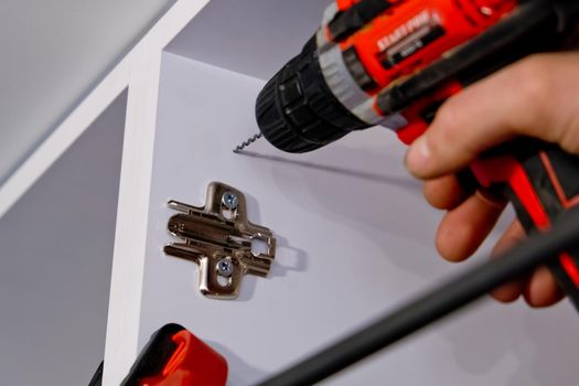 Drilling the kitchen cabinet for bonding.  Close up.