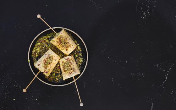 Saffron pistachio cream kulfi, traditional Indian dessert, ready to eat.  Top view, blank space