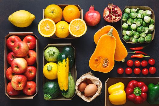 Paper boxes and bag of organic raw fruits and vegetables from the farmers market, clean eating, dieting and nutrition concept.  Top view, blank space