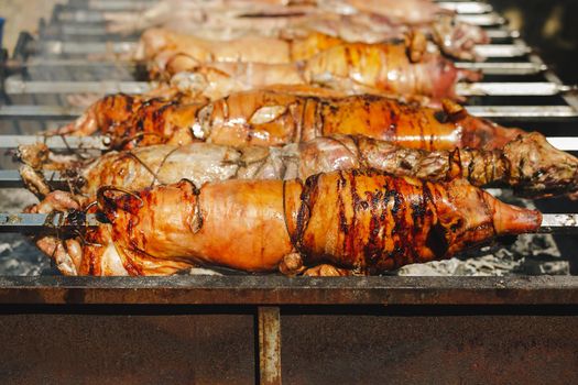 Crispy whole lamb and piglet  on a rotisserie  in the restaurant, selective focus