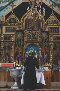 A person standing in front of icons. In a church