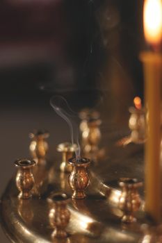 A close up of smoke in a candlestick in church