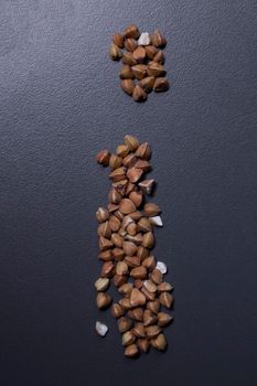 Letter 'i' written with buckwheat On gray background, top view, copy space. Food supplies crisis, food donation on quarantine isolation period