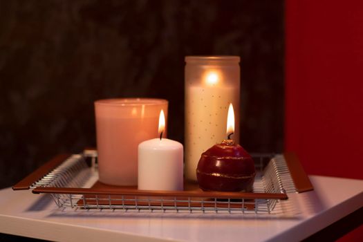 set of candles - pink and red - on a handmade metal tray. home interior and decor. High quality photo