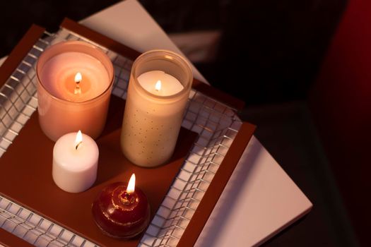 set of candles - pink and red - on a handmade metal tray. home interior and decor. High quality photo