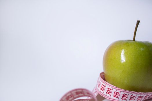 Red measuring tape over green apple. Diet and Healthy life, loss weight concept. Top view. Copy space. Isolated. White background. High quality photo