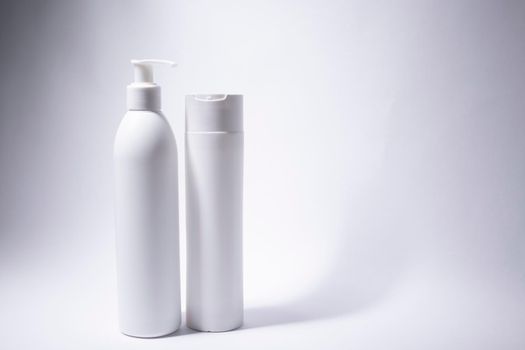 two white shampoo bottles and no label. body care and beauty concept. Copy space. High quality photo